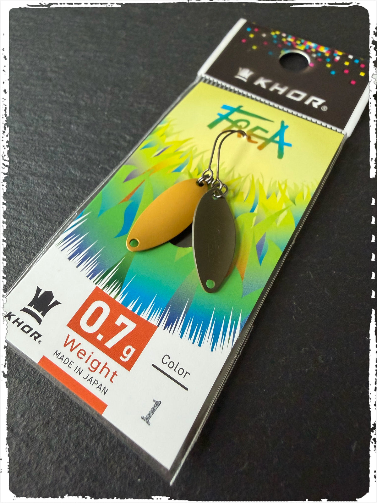 Khor Frea #FC01, 0,7 g: Löffelblinker (Vorder- und Rückseite) in Ocker und Oliv auf Karte