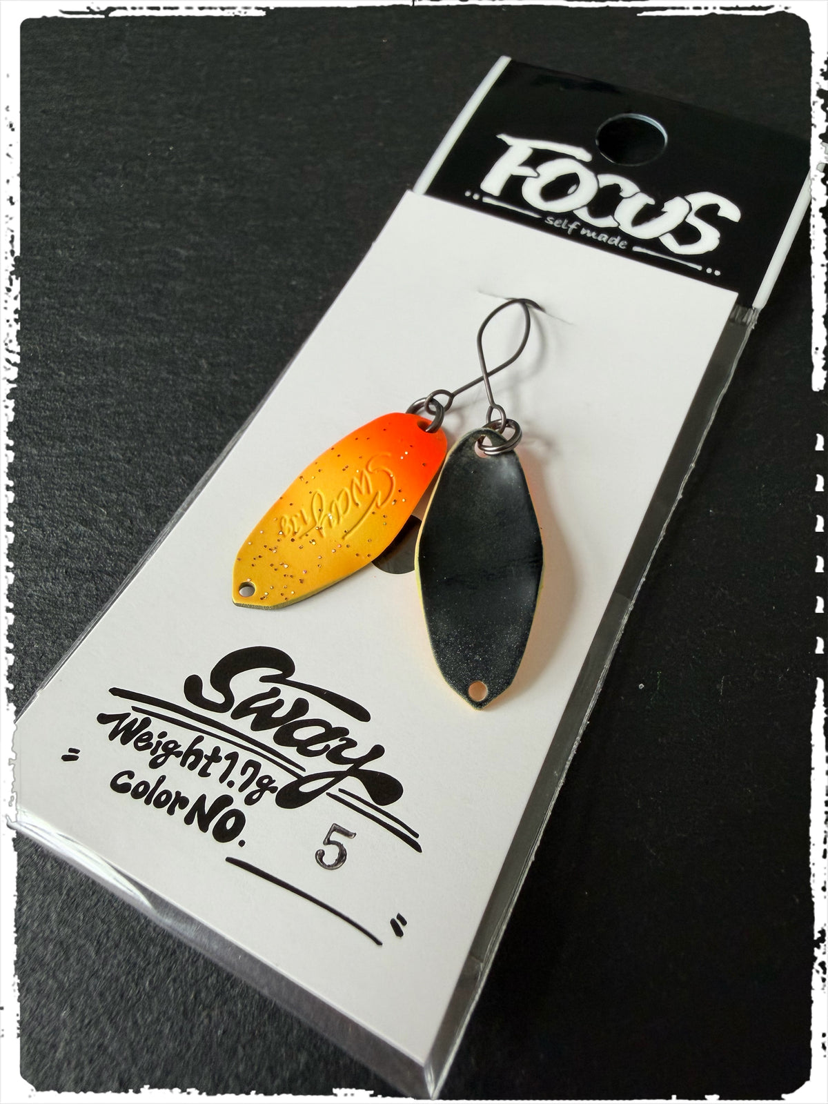 Angelköder-Blister mit zwei Löffelködern, gelb-orange und schwarz, am Haken