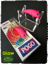 Wobbler mit fluoreszierendem pinkem Körper und zwei Drillinghaken, in Pogo-Box