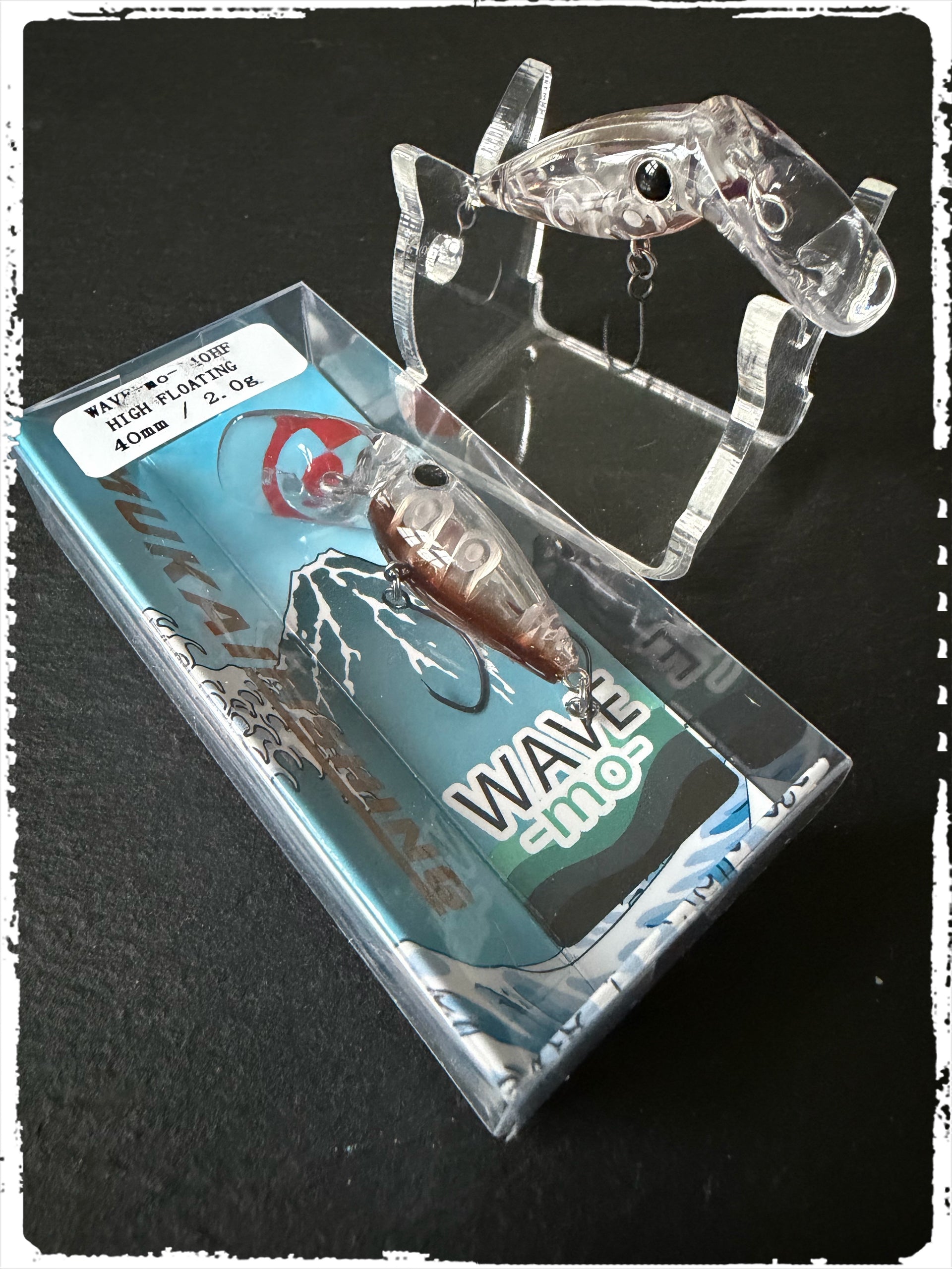 Mukai Wave-Mo Wobbler in transparentem Design, liegt auf Verpackung (Berry Line)