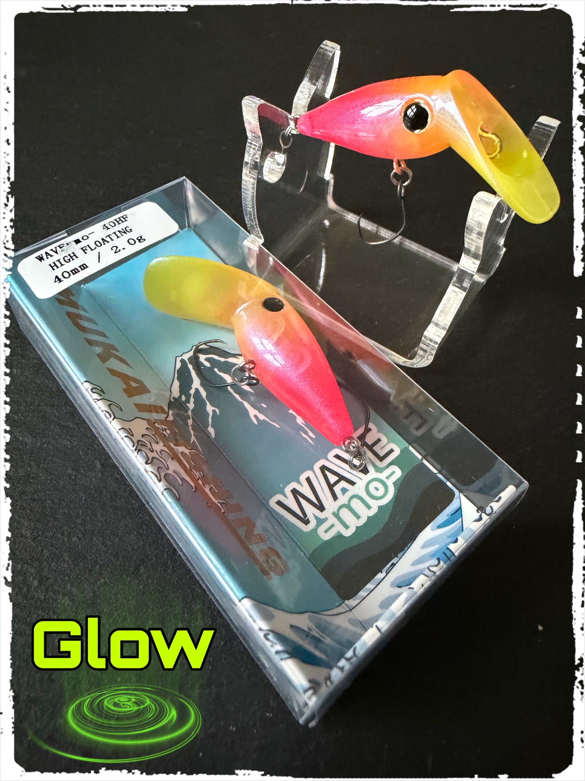 Angelköder (Wobbler) im transparenten Halter: orange-gelber und pink-roter Wobbler mit Drillinghaken