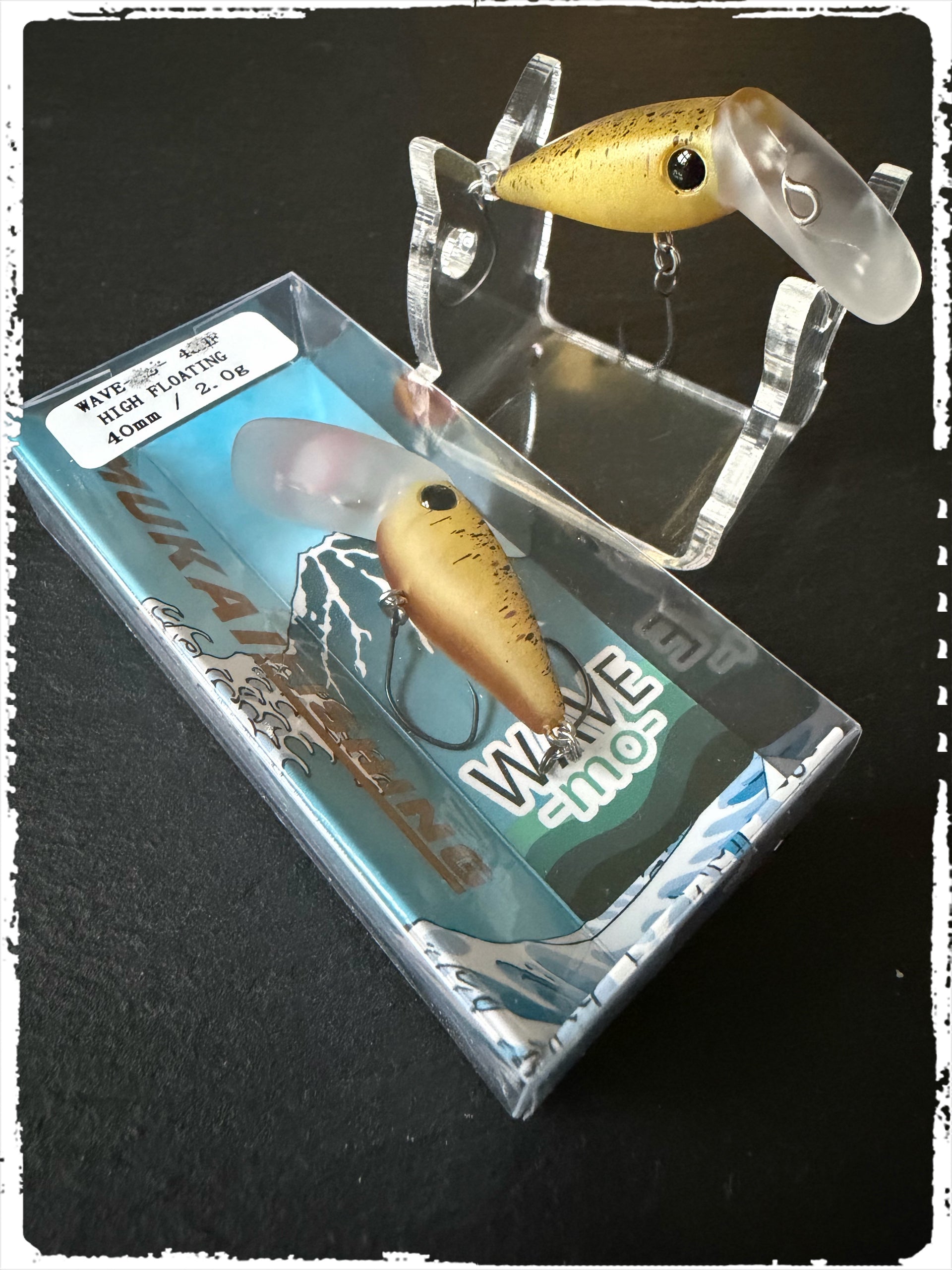 Mukai Wave-Mo Angelköder mit olivfarbenem Körper, in blauem Schuber