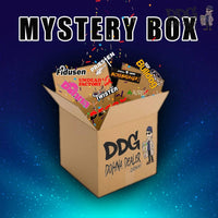 DDG Mystery-Box, offene Pappverpackung mit bunten Aufklebern
